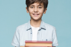 smiley-boy-holding-stack-books